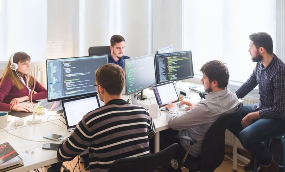 Equipo de desarrollo de software trabajando en aplicaciones a medida